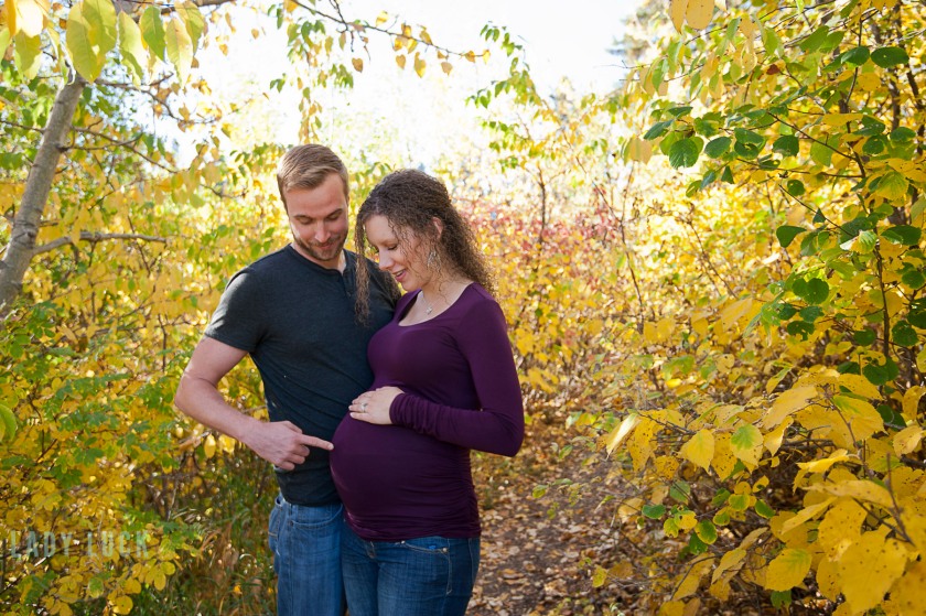 outdoor-maternity-session-edmonton-blackmud-creek-couple-looking-down-at-the-belly