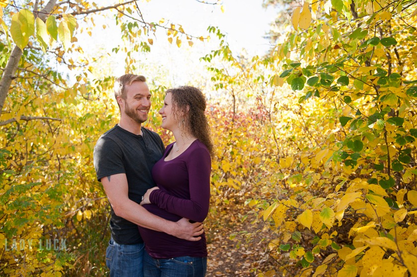outdoor-maternity-session-edmonton-blackmud-creek-couple-hugging-and-smiling-at-each-other