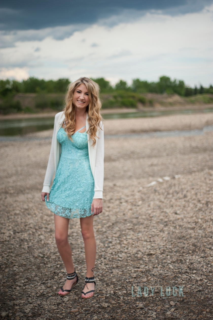 glamour-session-of-woman-standing-near-the-river-in-edmonton-on-a-rocky-beach